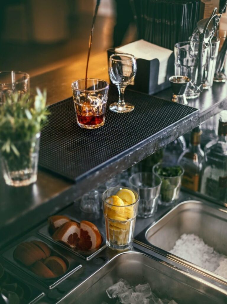 Conjunto de accesorios de bar, incluyendo vasos y herramientas, listos para preparar bebidas de calidad.