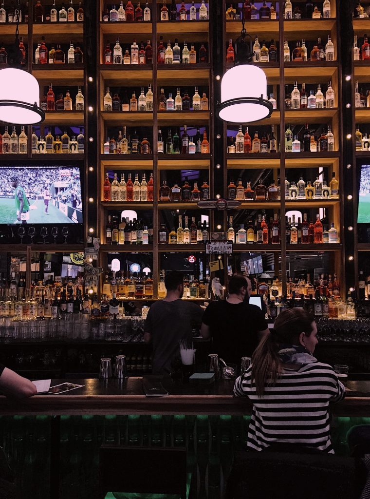 Vista interior de un bar, mostrando un ambiente acogedor y moderno con clientes disfrutando de su tiempo